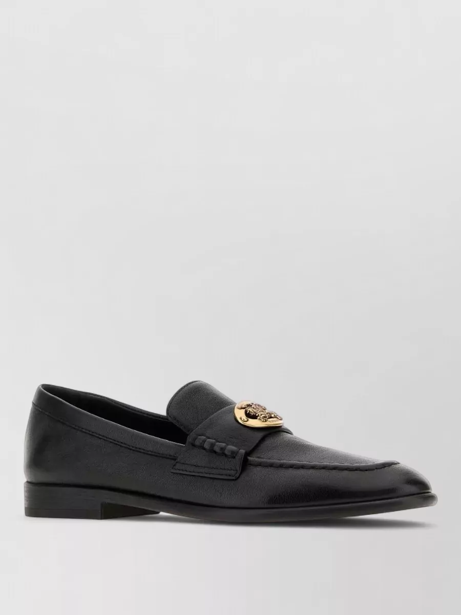 Burberry Leather loafers — The sleek black loafers in polished leather match the cardigan’s formality, pick up the black in the check, and lean into a preppy, office-ready mood rather than casual sneaker energy.