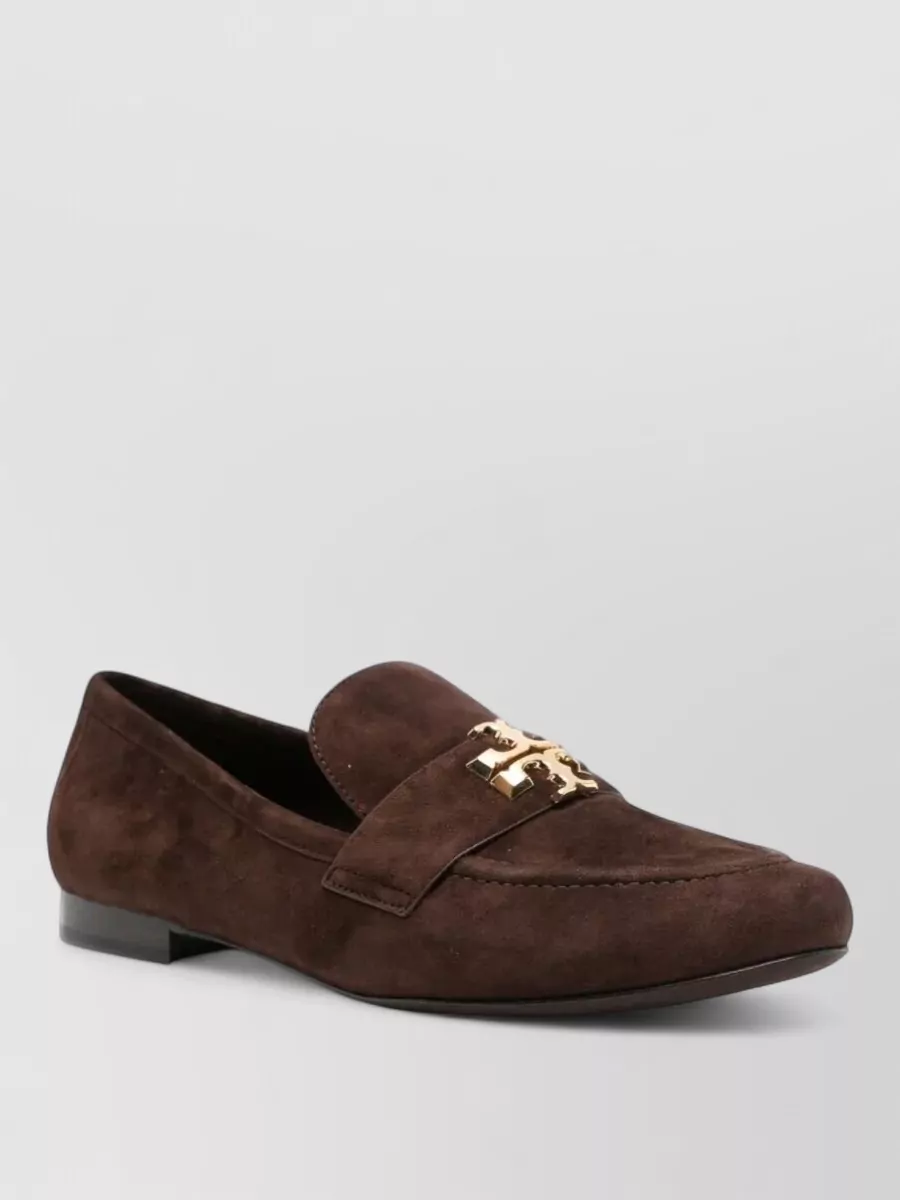 Tory Burch Leather loafers — The chocolate suede loafers echo the warm camel of the skirt and the plush textures, giving a refined preppy finish that suits the midi length and daytime formality.