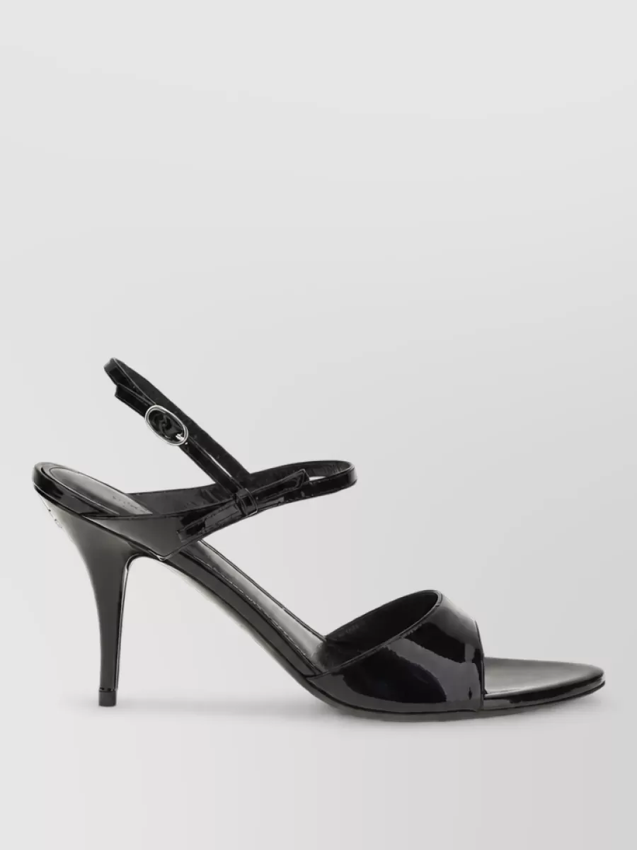 Balenciaga Leather avenue bow sandals — The Casadei champagne-gold strappy stilettos mirror the blazer’s light-gold buttons and keep the mood refined and evening-ready without adding visual heaviness to the sharp tailoring.