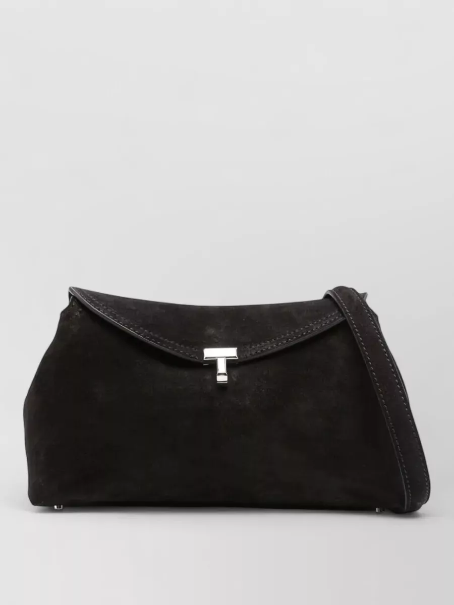 Totême Suede shoulder bag — The structured black Totême shoulder bag mirrors the trouser’s quiet tailoring, aligns with the minimalist aesthetic, and adds a discreet, high-end finish without competing with the simplicity.