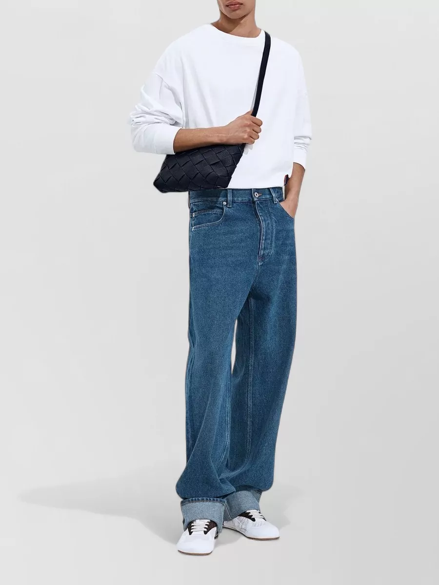 Bottega Veneta Wide-leg turned-up jeans — The Bottega wide-leg denim keeps the mood minimalist and street-led like the Balenciaga tee, while the relaxed volume and mid-indigo tone balance the boxy top in a clean, modern way.