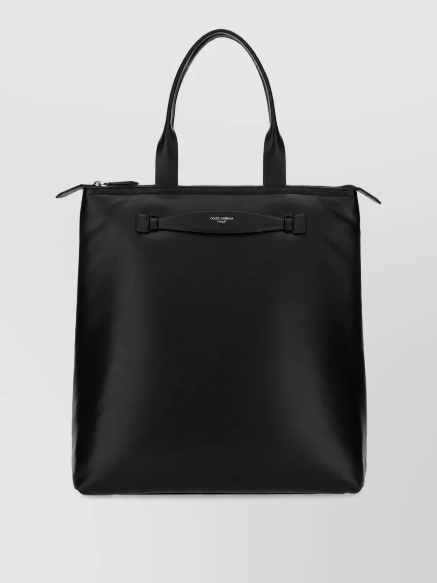 Dolce&Gabbana Leather tote bag — The structured black vertical tote feels polished yet easy, matching the monochrome palette and offering city-ready practicality that suits the refined but relaxed nature of the outfit.