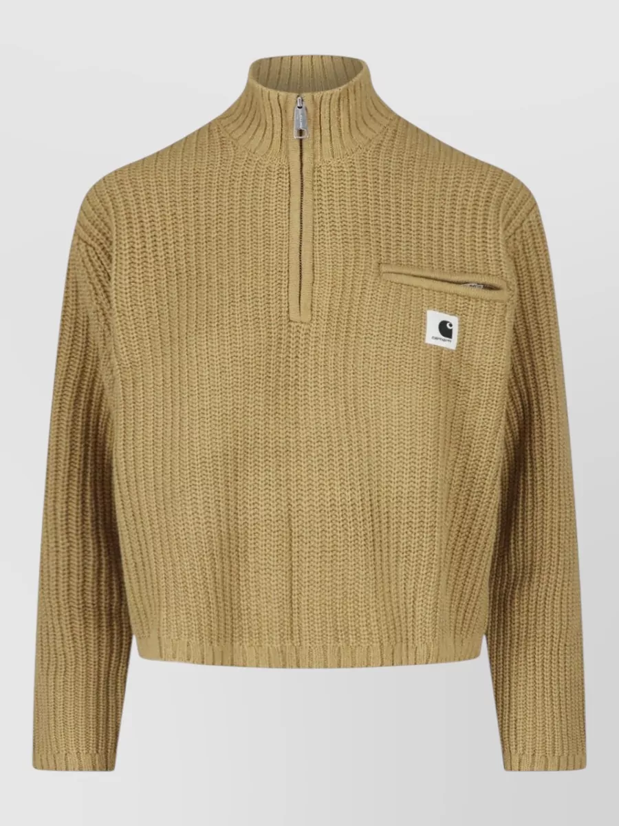 Carhartt Wip Crewneck jumper — The S Max Mara camel hooded knit mirrors the parka’s warm neutral palette and minimalist-sport mood while adding a refined, longline layer that sits smoothly under the short, technical shell.