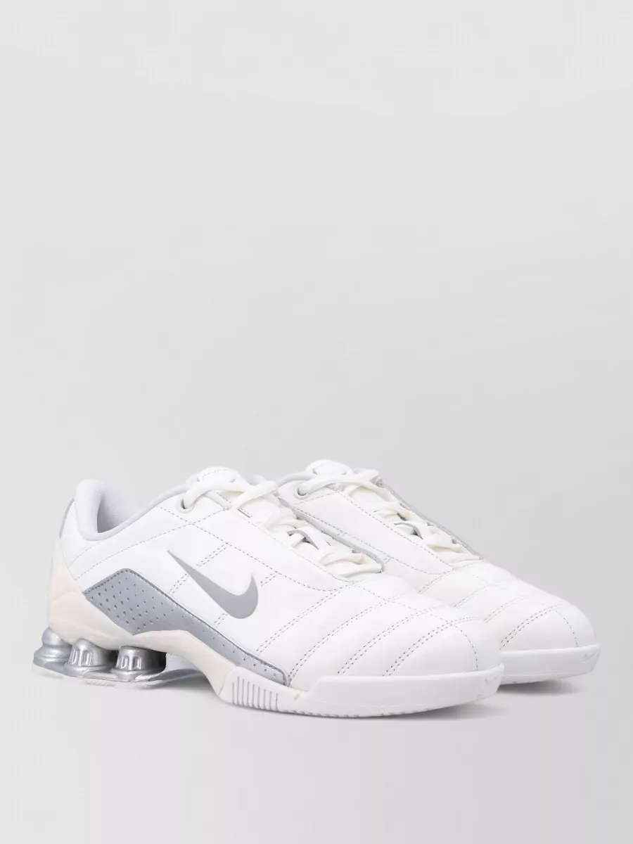 Nike Leather low-top sneakers — The white and light grey Nike low-top sneaker keeps things sporty and streamlined, tying into the gilet’s technical vibe without adding visual bulk at the hem.