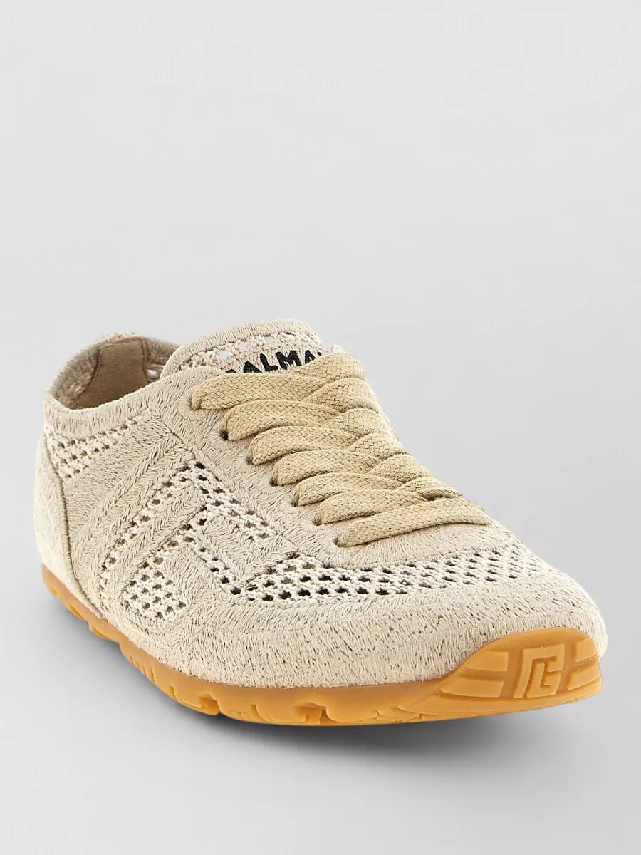 Balmain Macramé lace-up sneakers — The Balmain woven sneakers in sand and gum tan align perfectly with the skirt’s utility vibe and neutral palette, keeping the outfit grounded yet refined for warm-weather city wear.