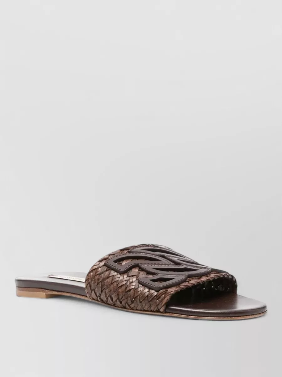 Casadei Leather flat sandals — The dark brown woven Casadei slides echo the bag’s chocolate trim and artisanal texture, grounding the pale dress in a relaxed boho-minimal mood that works for warm days.