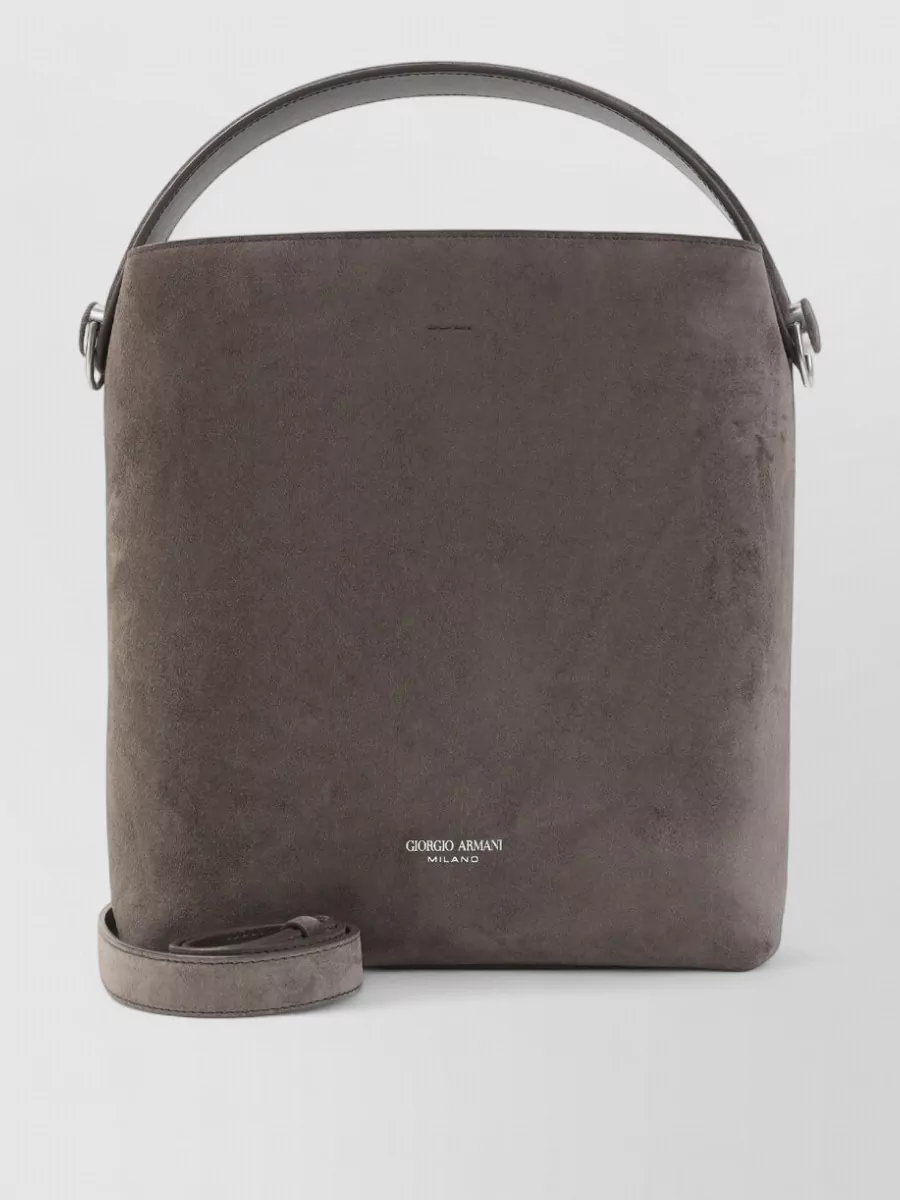 Giorgio Armani Suede shoulder bag — Giorgio Armani’s charcoal-taupe suede cross-body keeps to the same dark neutral spectrum and refined tier, adding structure without visually fighting the robe’s pattern and fringe.