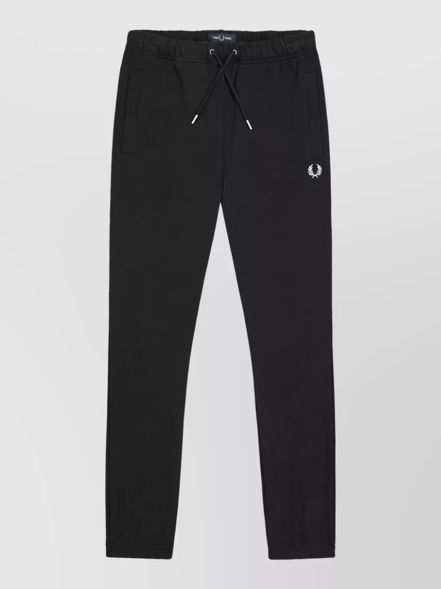 Fred Perry Cotton track pants — The black tapered Fred Perry track pant matches the brand, palette and casual sport energy of the parka, creating a clean head-to-toe line ideal for winter streetwear.