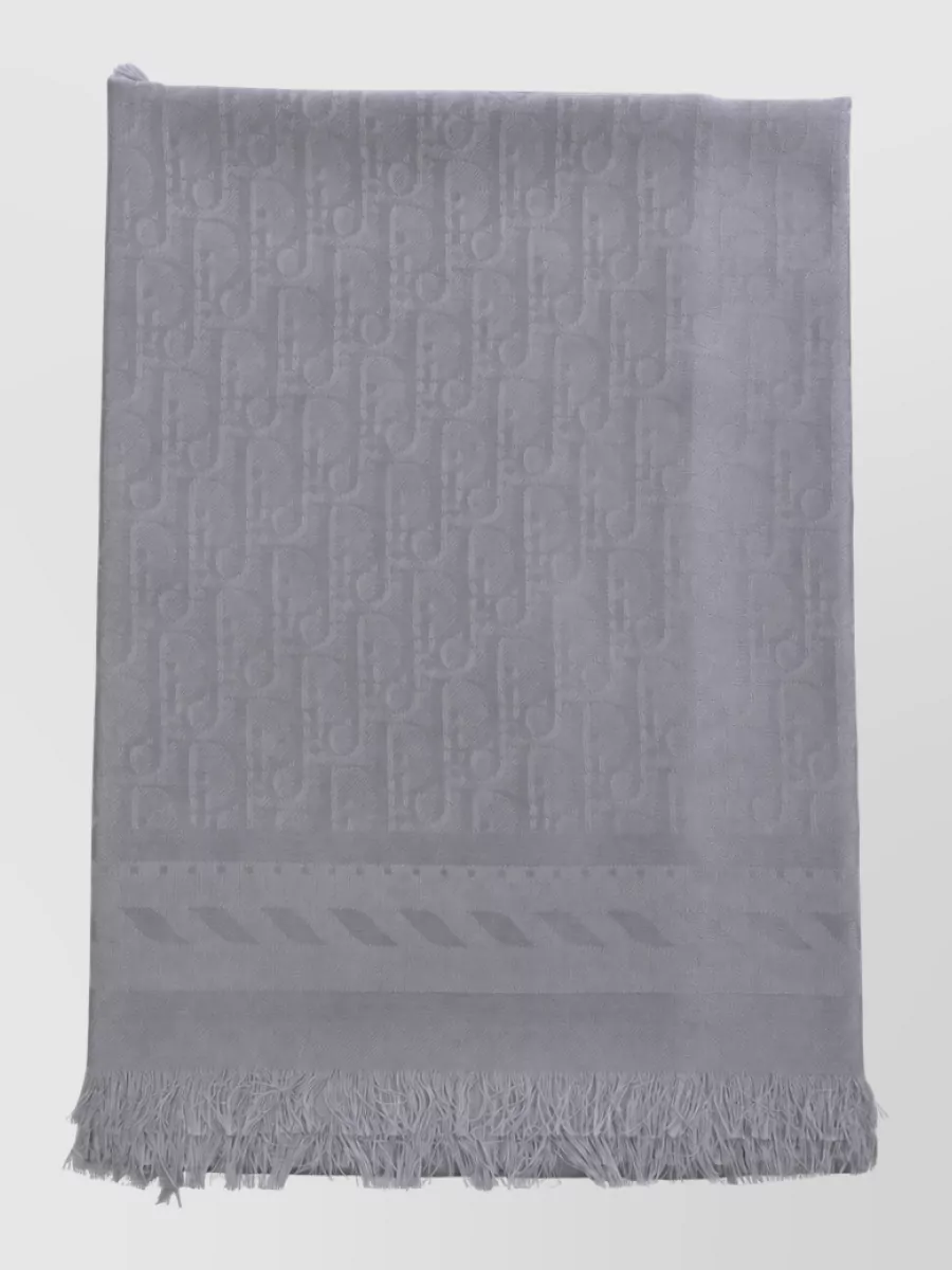 Christian Dior Silk wool scarf — The dove-grey Dior scarf quietly bridges the ivory knit and charcoal trouser, adding a slim vertical line and subtle texture that reinforce the polished, minimal character.