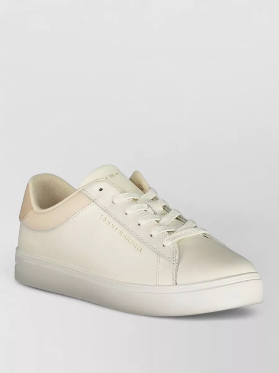 Tommy Hilfiger Leather lace-up sneakers — The warm ivory Tommy Hilfiger sneakers keep the outfit relaxed yet neat, harmonising with the shirt’s soft creams and working cleanly with the richness of the brown trouser.