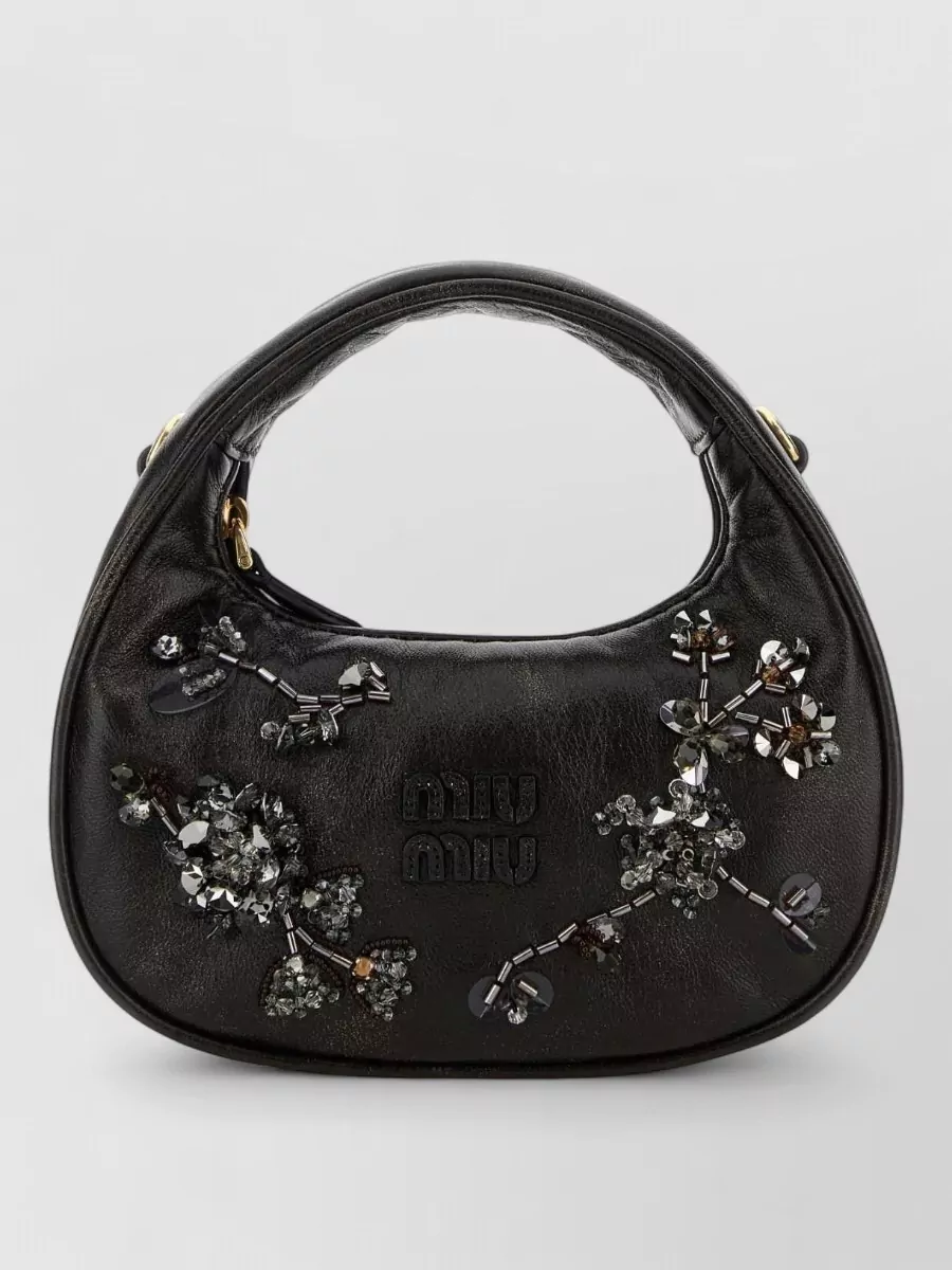 Miu Miu matelassé nappa leather shoulder bag — The Miu Miu black top-handle with gunmetal crystals harmonises perfectly with the dress’s liquid metal draping and Y2K romance while maintaining a high designer tier and compact evening scale.