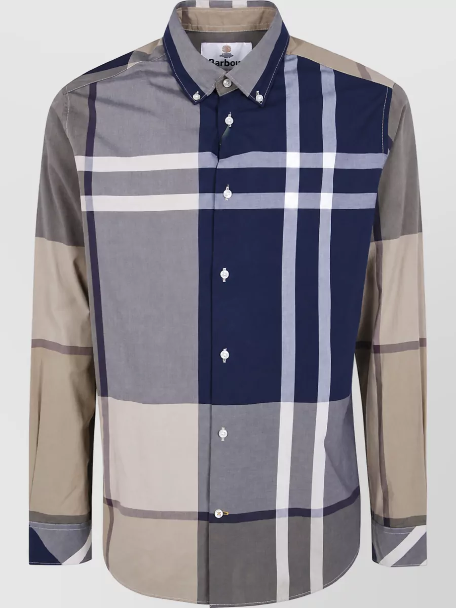 Barbour Cotton checked shirt — J’s oversized navy, stone and taupe plaid mirrors the overshirt’s navy-slate-taupe checks in both scale and palette, giving a graphic but controlled check-on-check that still feels quietly polished.