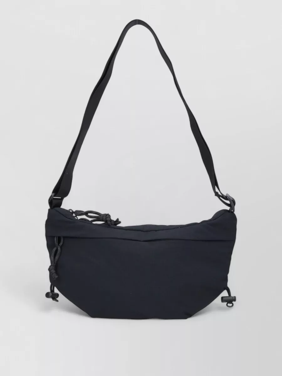 The North Face Shoulder bag — The North Face black crescent crossbody is compact, hands-free and technical, aligning with the athletic mood without overwhelming the pared-back outfit.