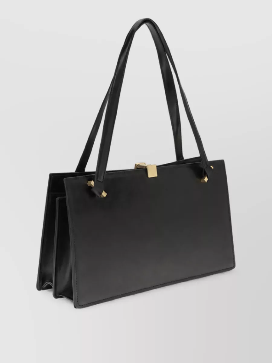 Versace Calf leather shoulder bag — The structured black shoulder bag with bold gold clasp mirrors the hardware story and tailored mood, adding refined Versace branding without competing with the trousers’ drama.