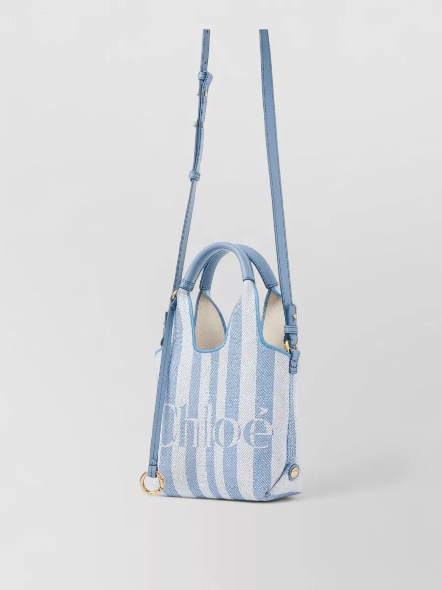 Chloé woody mini cotton tote bag — The Chloé striped mini tote in powder blue and chalk ties into the shorts’ blue denim and sunny palette while its canvas texture and slim shape keep the ensemble light and slightly preppy-boho.
