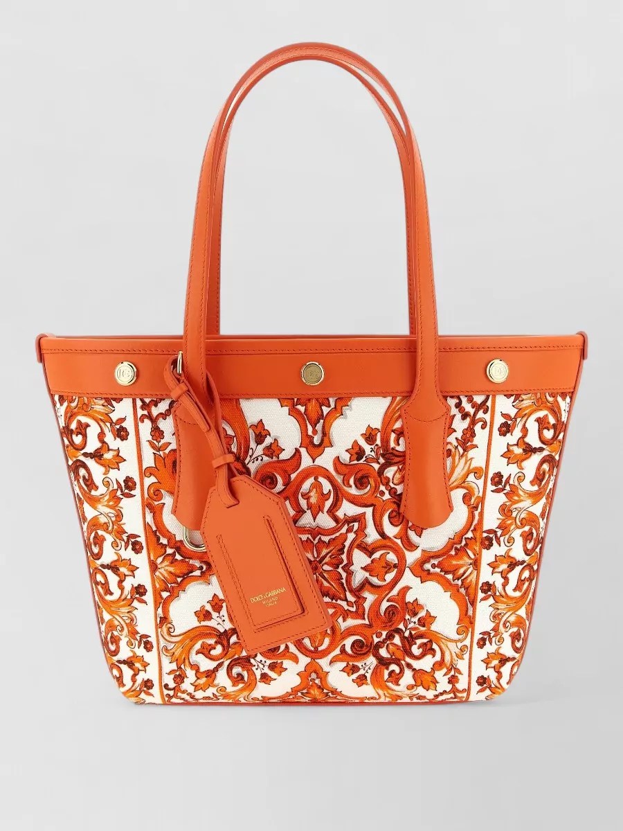 Dolce&Gabbana small shopping canvas shoulder bag — The structured orange-and-ivory printed tote harmonises perfectly with the shorts’ baroque motif and color story while its clean shape adds polish to an otherwise playful, resort-leaning outfit.