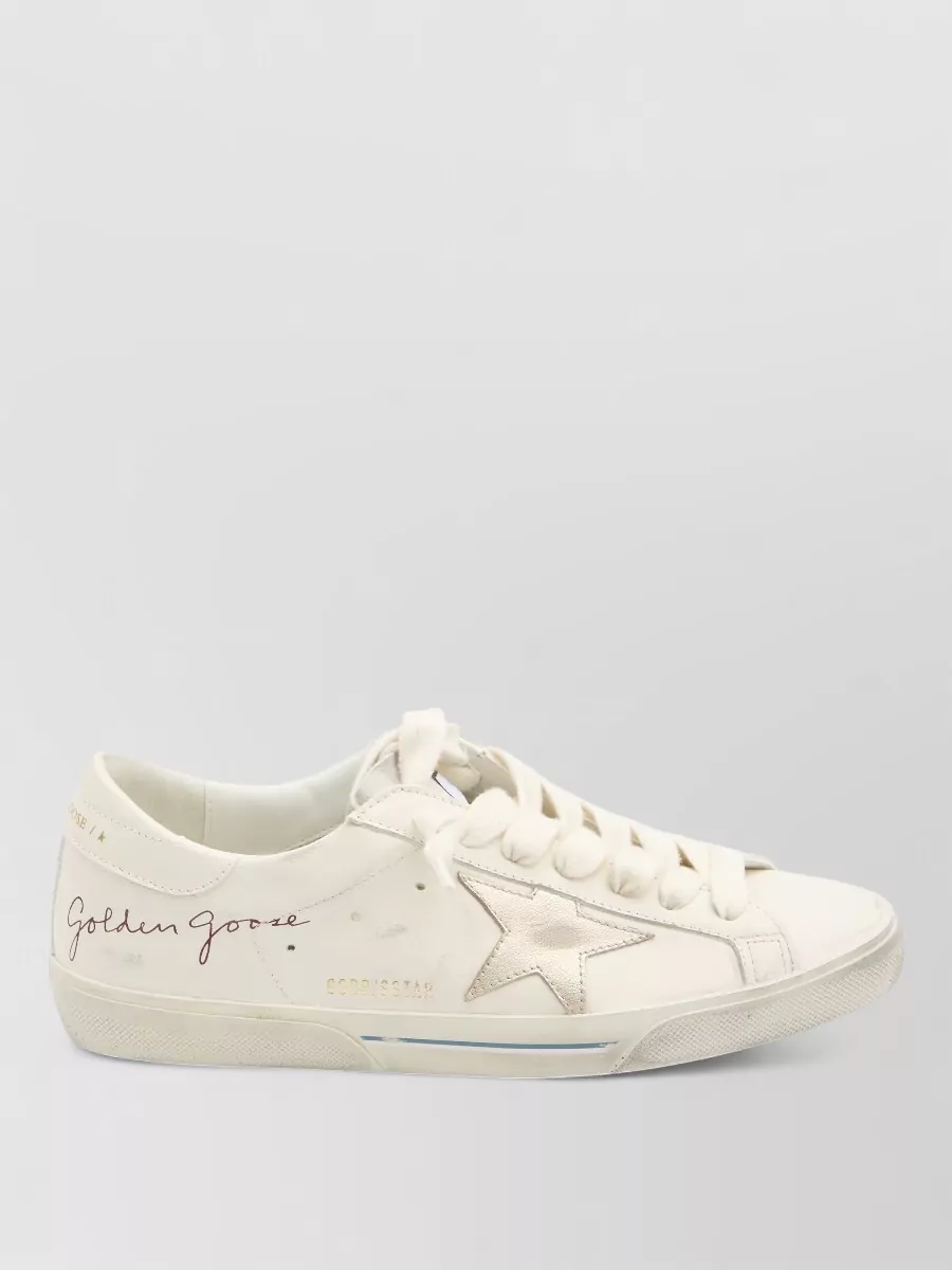 Golden Goose Leather super star low-top sneakers — Golden Goose’s off-white low-top keeps the look relaxed and discreet, echoing the light tones of the trousers and polo without competing with the belt’s monogram or introducing more check.