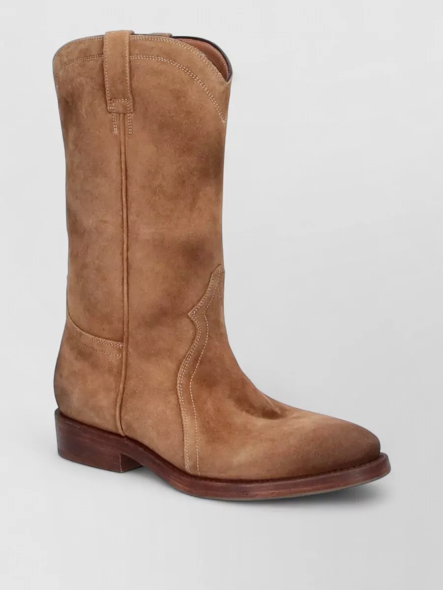 Jil Sander Suede ankle boots — The Jil Sander camel suede mid-calf Western boot quietly mirrors the bag’s cognac suede and boho-Western reference while grounding the maxi dress with a refined, walkable heel.