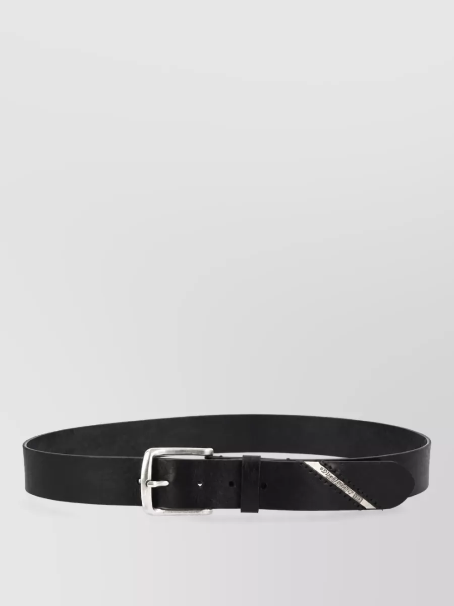 Diesel Leather belt — The clean Diesel black belt with classic silver buckle quietly grounds the relaxed jeans and reinforces the industrial edge without competing with the distressed textures elsewhere.