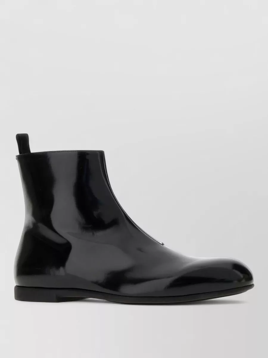 Jil Sander Leather ankle boots — The glossy, ultra-clean ankle boot reinforces the sculptural, almost futuristic edge of the shirt and wide-leg trouser, grounding the outfit in sharp, evening-ready polish.