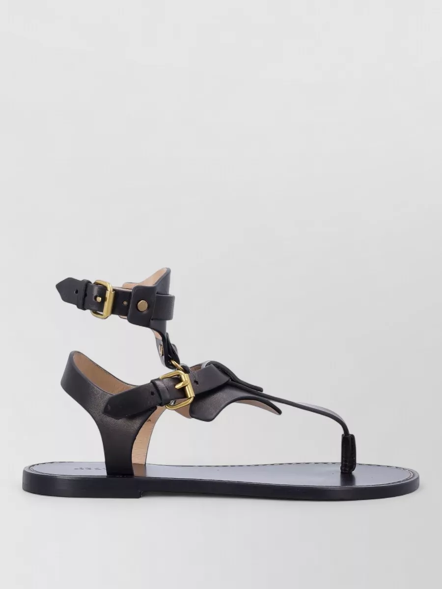Isabel Marant Leather embellished thong sandals — The black flat gladiator sandal feels right for summer evenings, repeats the blouse’s dark ground and keeps the whole silhouette light and bohemian rather than heavy.