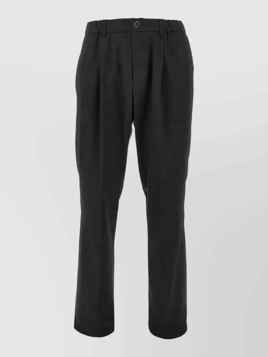 Herno Tailored trousers — The pleated, tapered charcoal-black trouser keeps the line sharp but relaxed, matching the tee’s quiet luxury and formality while giving a clean, modern leg shape for fall and winter.