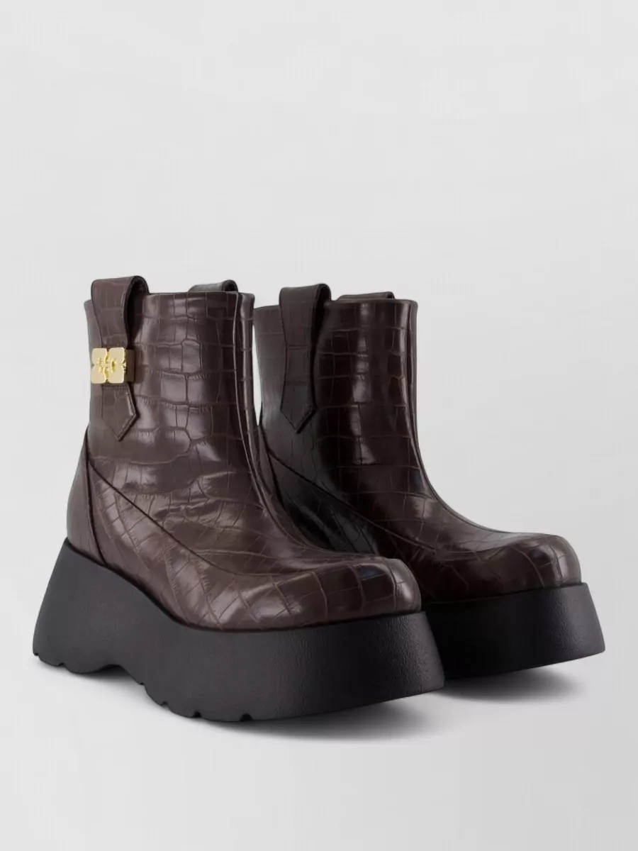 Ganni Leather ankle boots — The chunky dark-brown platform ankle boots ground the wide-leg jeans, tie into the caramel tones of the sweatshirt graphic, and feel winter-ready while staying firmly in the streetwear space.