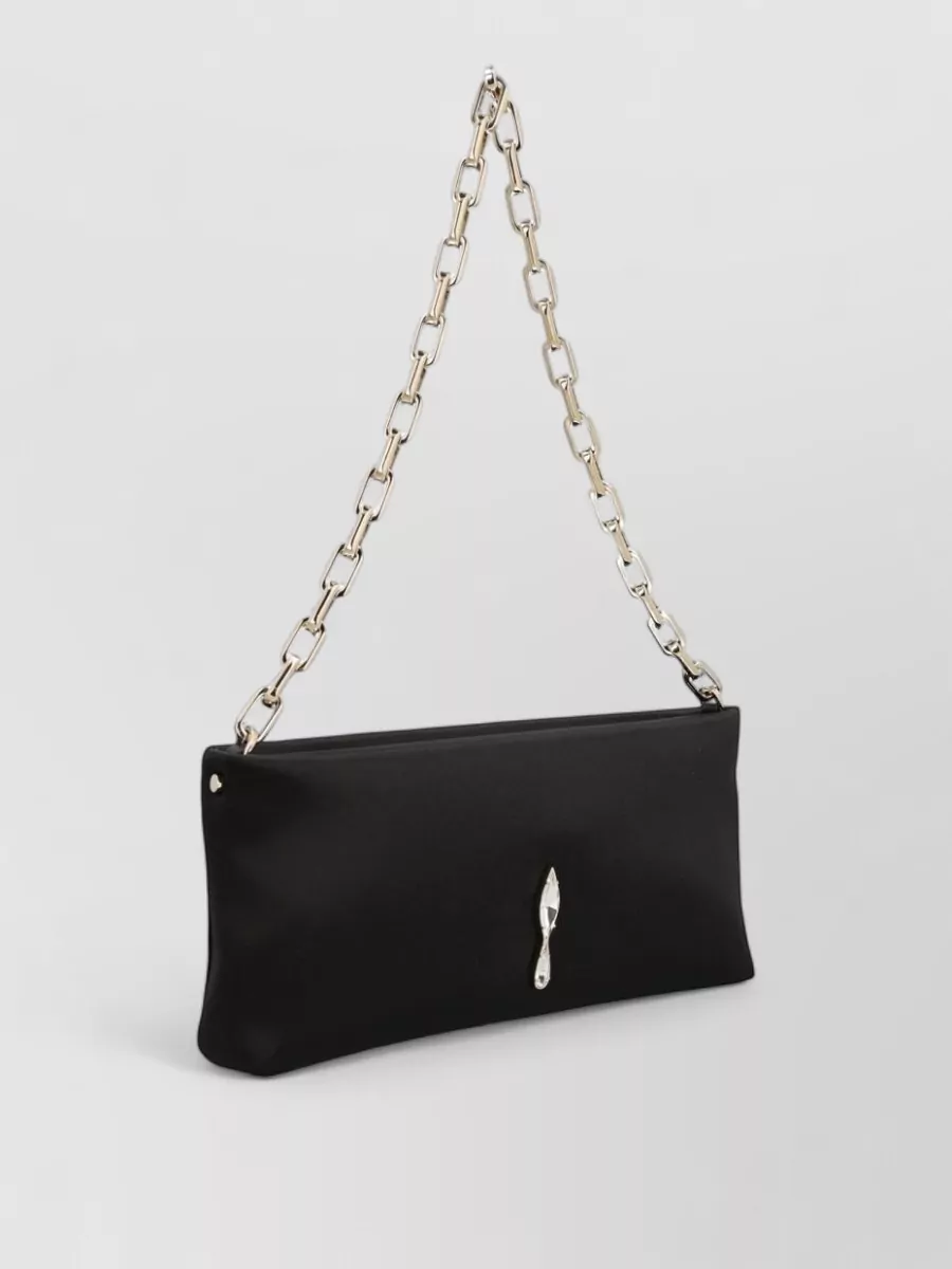 Christian Louboutin Satin crystal-embellished clutch bag — The Jacquemus black-and-gold elongated clutch matches the sandal’s refinement and formality, echoing the slim silhouette and metallic hardware without competing with the fluid satin dress.