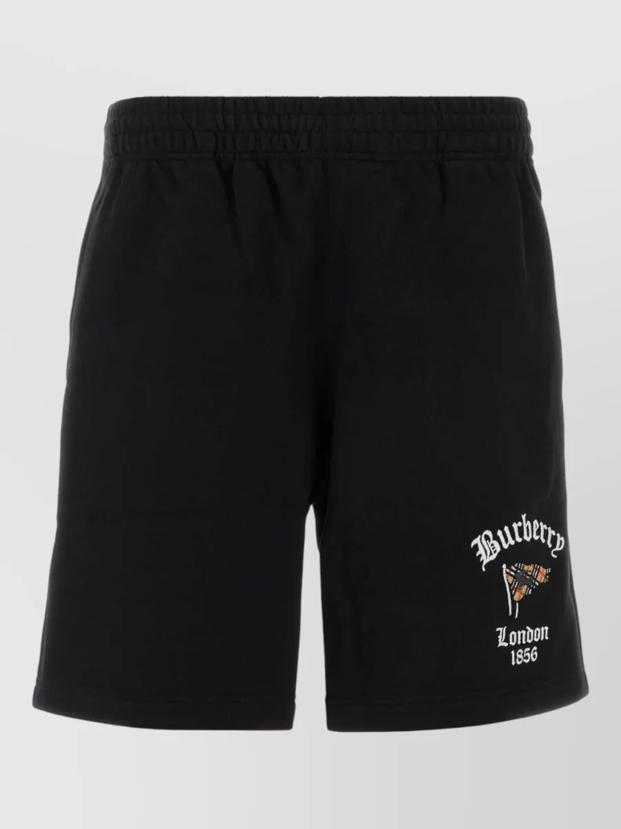 Burberry Cotton chino shorts — The black Burberry shorts with subtle heritage branding match the sandal’s black base and luxury tier, giving a polished athletic proportion that suits the slides for city or poolside wear.