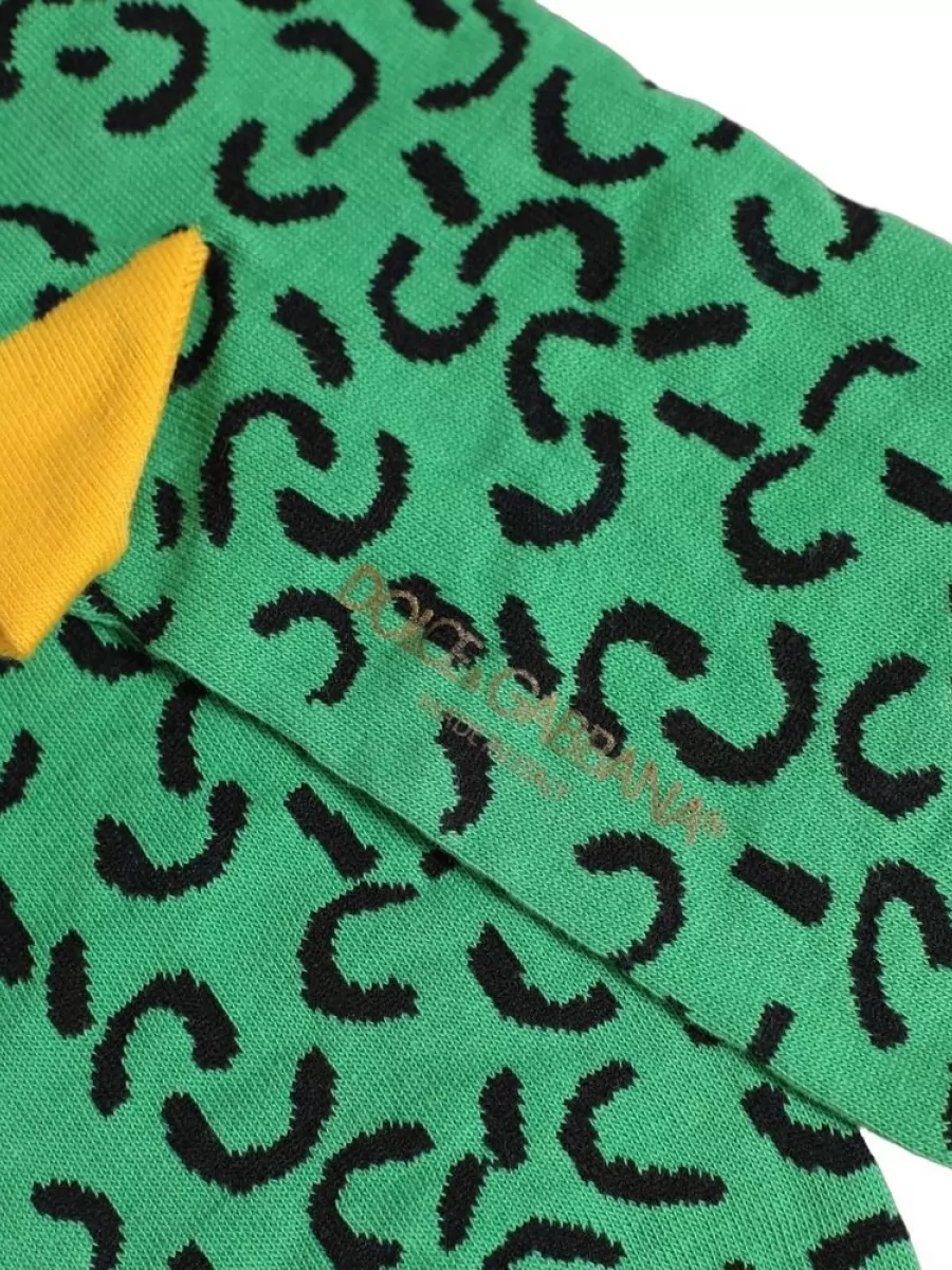 Dolce&Gabbana Abstract mid calf socks — The green patterned socks quietly echo the tee’s color and graphic feel, giving a coordinated pop above the white sneakers that ties the palette together.