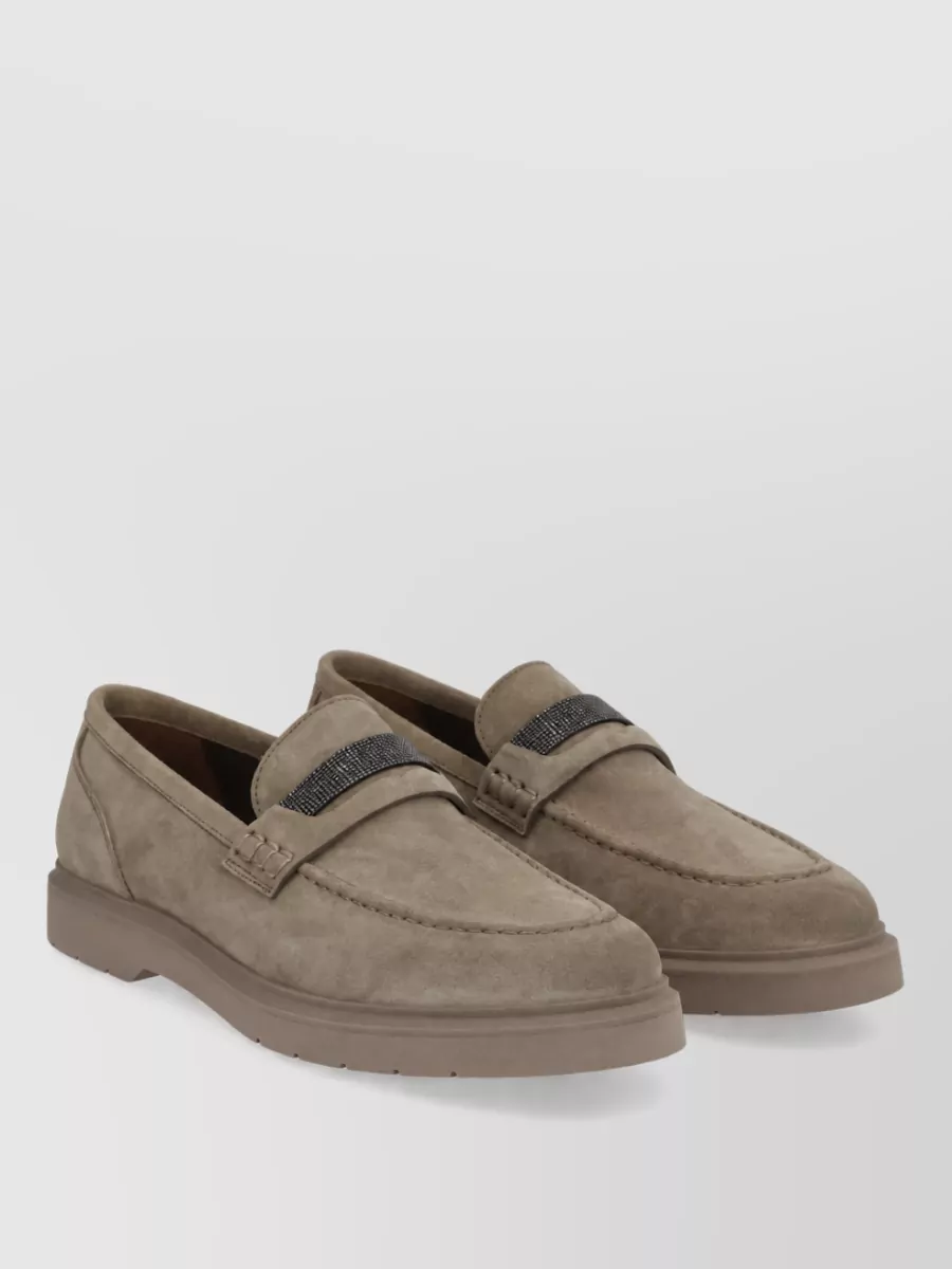 Brunello Cucinelli Leather loafers — The sand suede Chelsea boots offer a clean, slightly dressier finish in a soft neutral that elongates the line of the wide-leg trousers while keeping the outfit discreetly luxurious and practical for cooler weather.