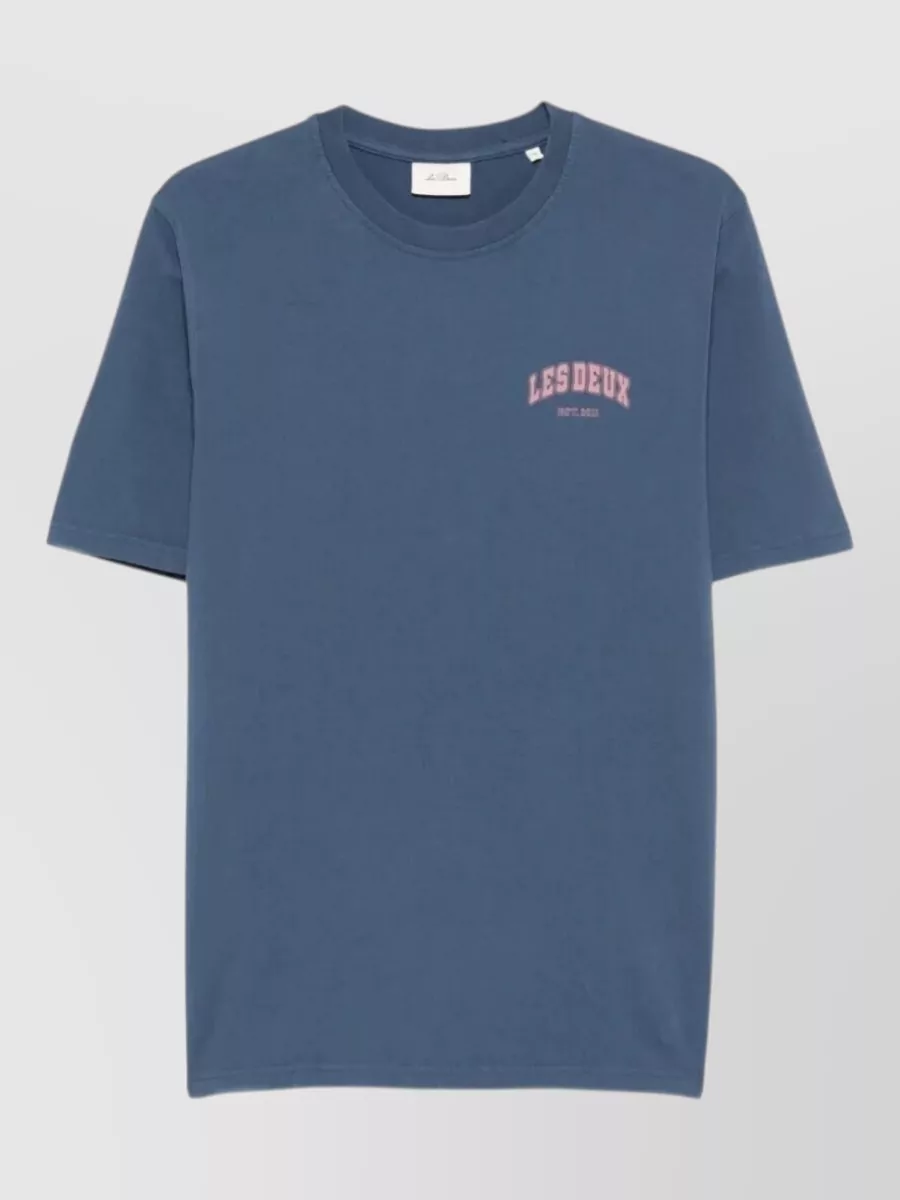 Les Deux Organic cotton brady hoop t-shirt — The washed slate blue tee with soft pink collegiate logo echoes the mid blue trucker while adding a subtle color accent that still feels casual and cohesive.