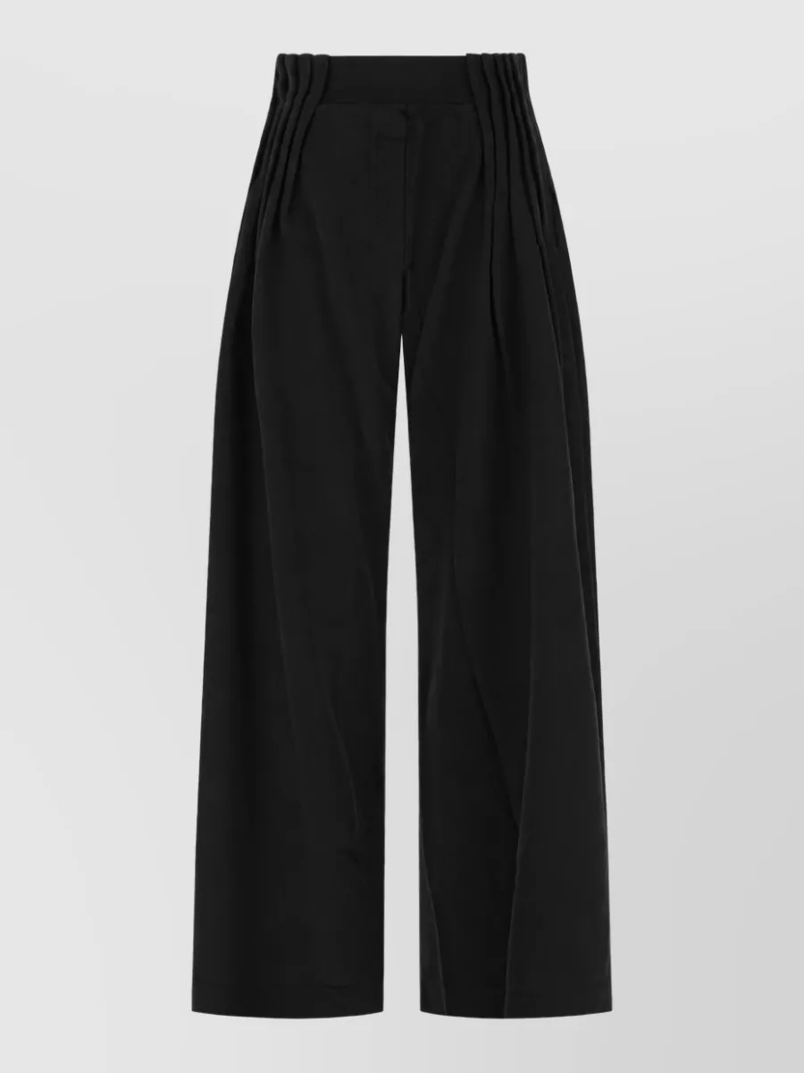 Dries Van Noten Wide-leg trousers — The high-rise black wide-leg trouser keeps the focus on the pixel shirt while matching its tailored, streetwise attitude and formality, creating a clean long column that works for fall and winter.