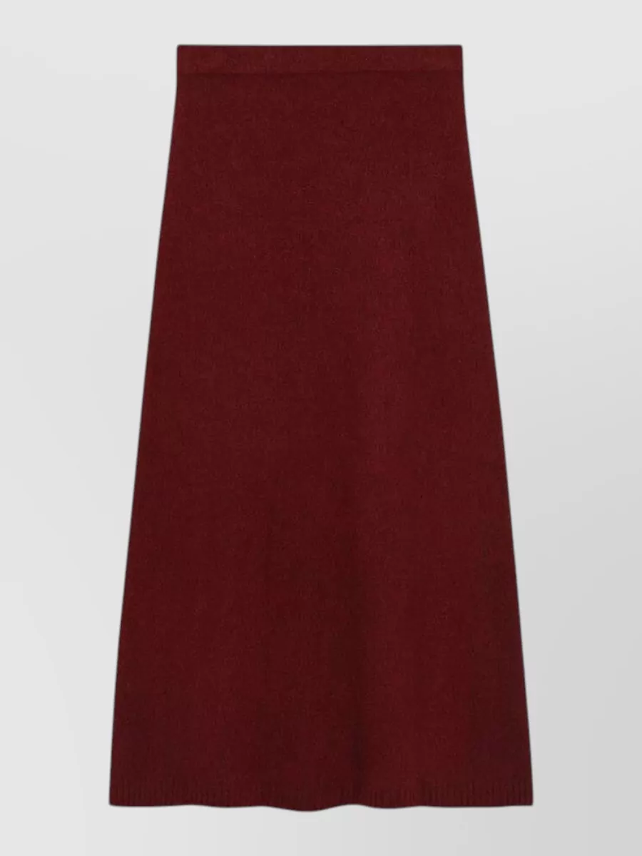 Max Mara Cashmere a-line skirt — The Max Mara burgundy A-line midi mirrors the knit’s tone for a column of color, keeps the formality quietly polished and elongates the silhouette in a minimalist way.