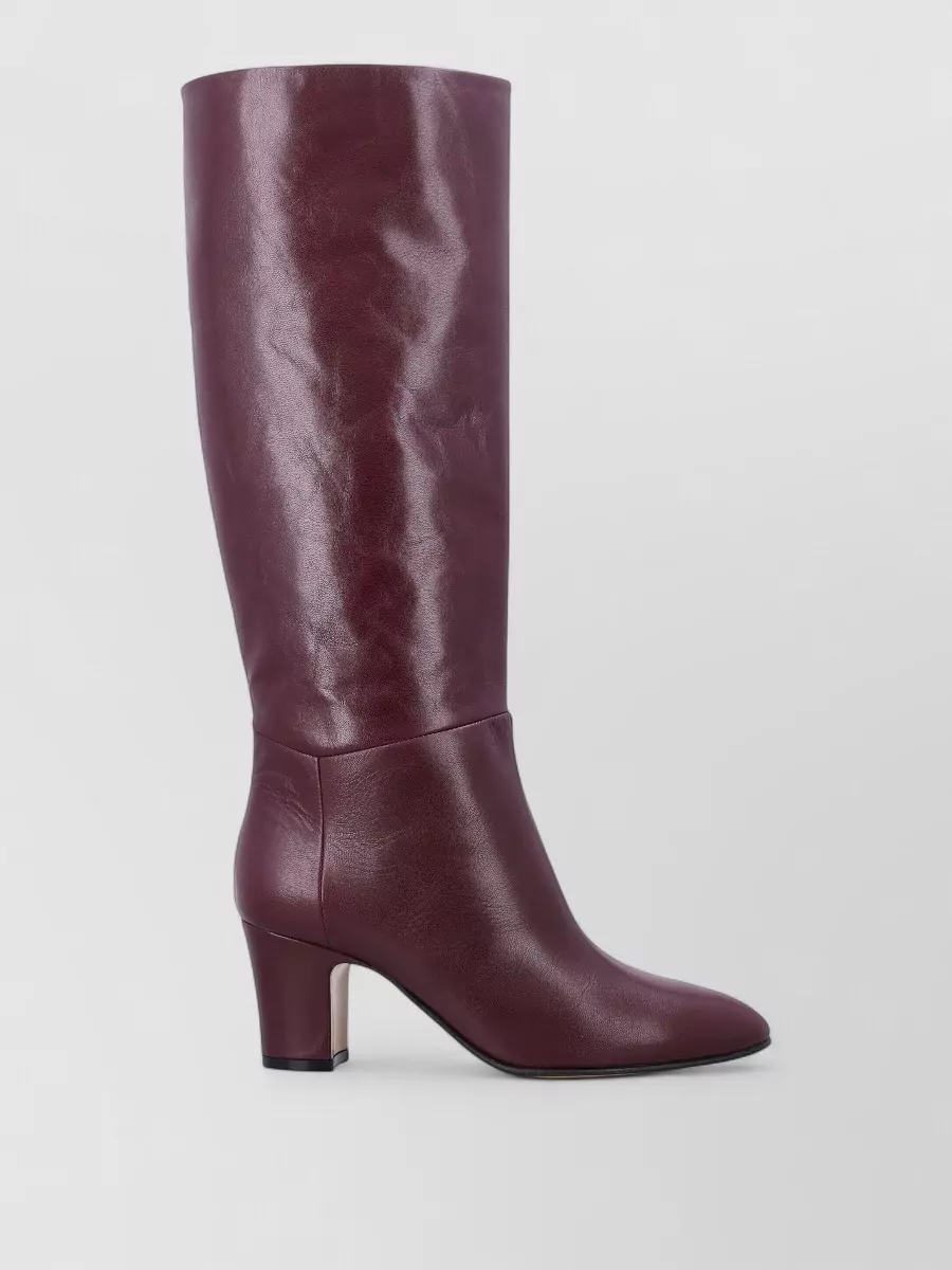 Alberta Ferretti Leather knee-high boots — The burgundy knee-high boots extend the skirt’s color into a continuous column and their block heel keeps the quietly luxurious mood aligned with the knit’s understatement.
