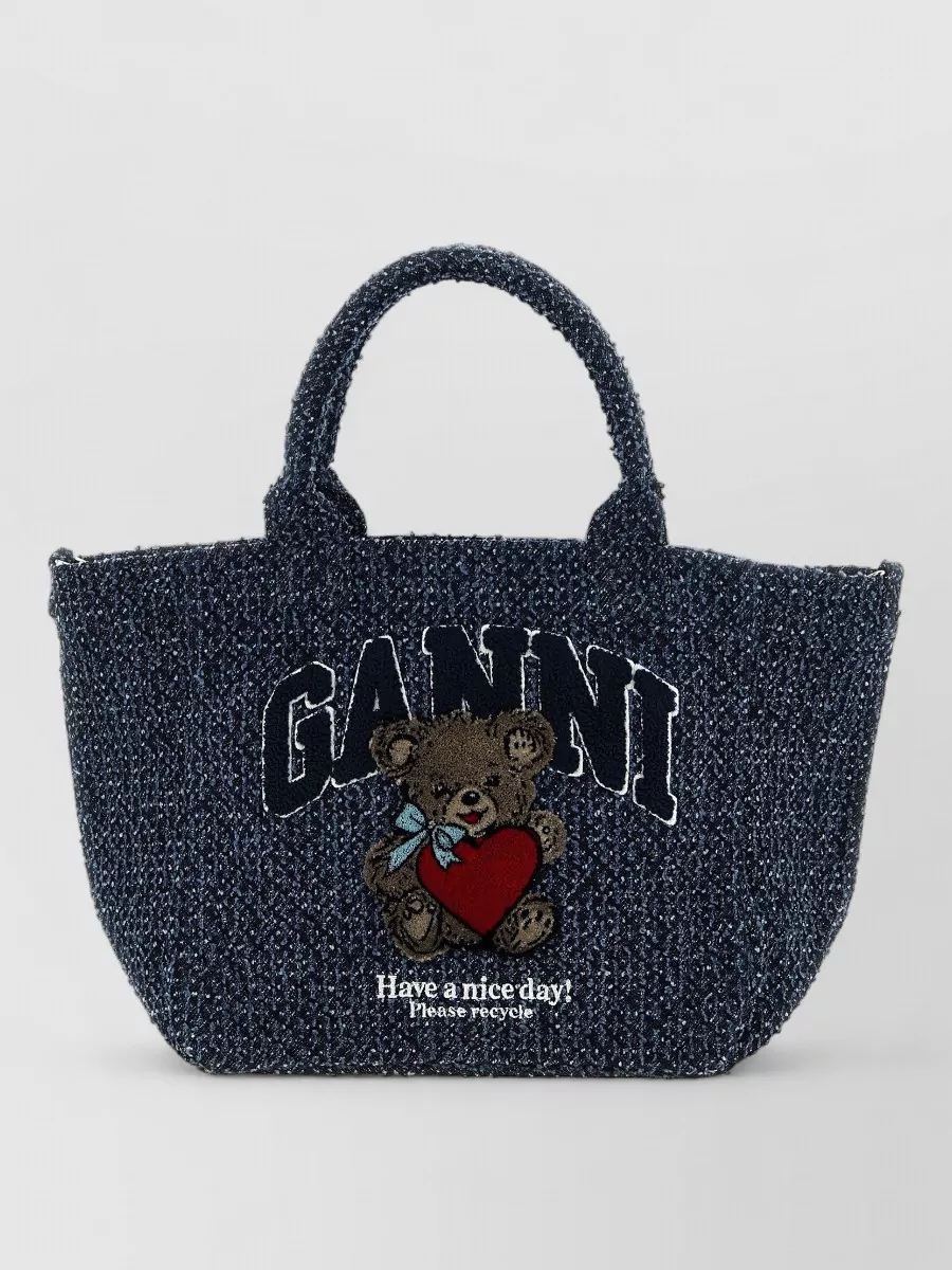 Ganni cabas small cotton tote bag — The navy mélange medium tote with varsity teddy logo ties into the tee’s preppy graphic story and offers a more polished scale than the oversized beachier options.