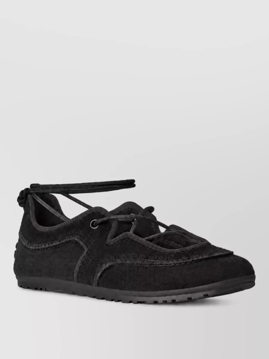 Ugg Leather lace-up ballet sneakers — The black Ugg lace-up sneakers echo the sock ribbons, keep the palette all-black and sport-minimal, and feel city-ready with a long knit dress.