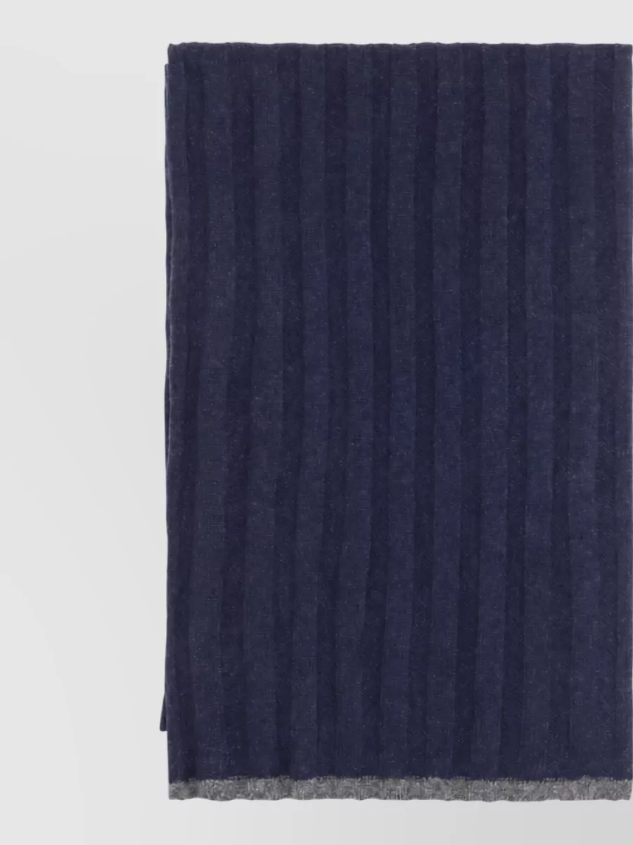 Brunello Cucinelli Cashmere scarf — The Brunello Cucinelli navy ribbed scarf reprises the vertical rib and deep navy of the knit, reinforcing the column effect and keeping the palette tightly controlled for winter.
