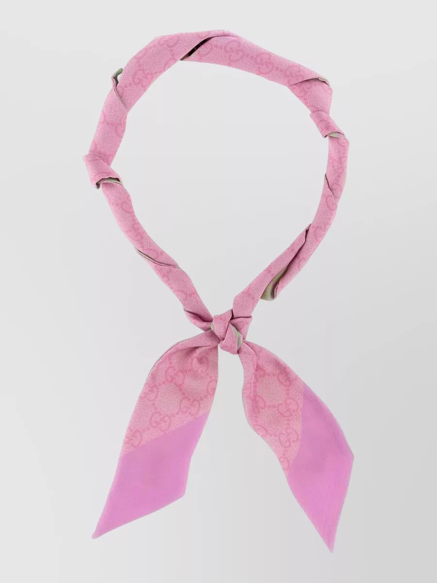 Gucci Silk printed scarf — The Gucci pink neckerchief plays up the tee’s heart-pink notes and can sit at the neck or on the bag handle for a subtle, playful color echo without cluttering the silhouette.