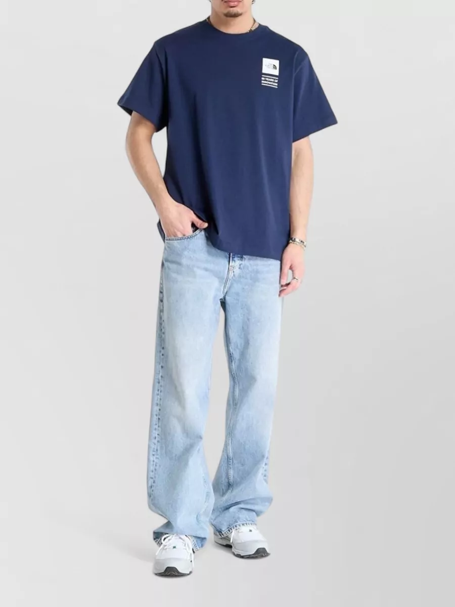 The North Face Cotton short-sleeve t-shirt — The navy tee in K keeps the palette tight with the navy shell, feels light for warm weather, and supports the minimalist technical mood without adding bulk under the jacket.