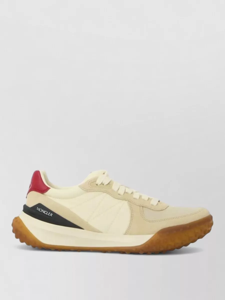 Moncler City trek low-top sneakers — Moncler’s cream and gum runners introduce a lighter base and premium contrast while still reading sporty, which lifts the all-navy Ralph Lauren set without breaking its casual level of formality.