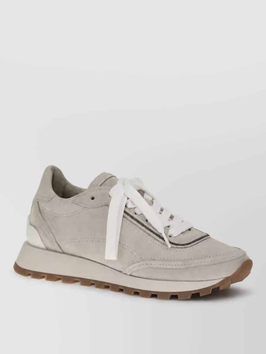 Brunello Cucinelli Leather lace-up sneakers — The warm stone runner keeps the outfit quietly relaxed yet luxe, its light neutral tones aligning with the tee and trousers while the low profile flatters the wide-leg cut.