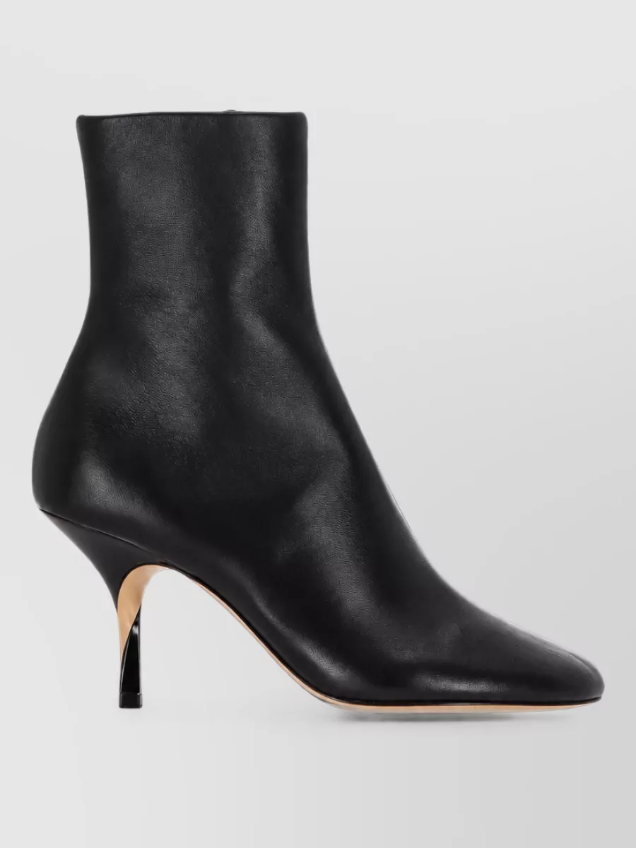 Jacquemus Leather ankle boots — The sleek black pointed ankle boots with a slim sculptural heel match the skirt’s formality, echo the cardigan’s sharp minimalism, and visually lengthen the flared midi for modern evening polish.