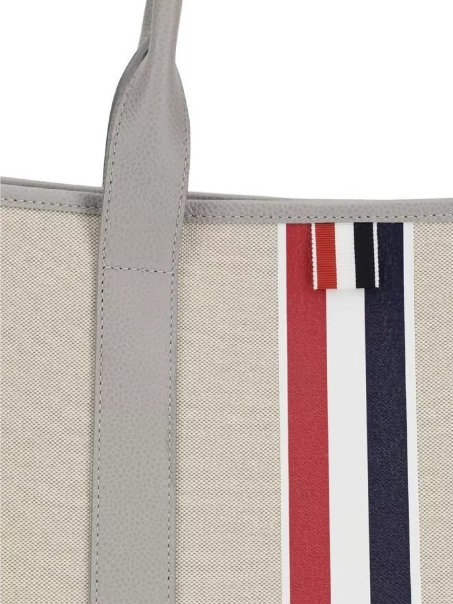 Thom Browne Fabric tote bag — The Thom Browne light beige and grey canvas tote harmonises with the neutral palette and tailored mood, adding structure without breaking the minimalist aesthetic.