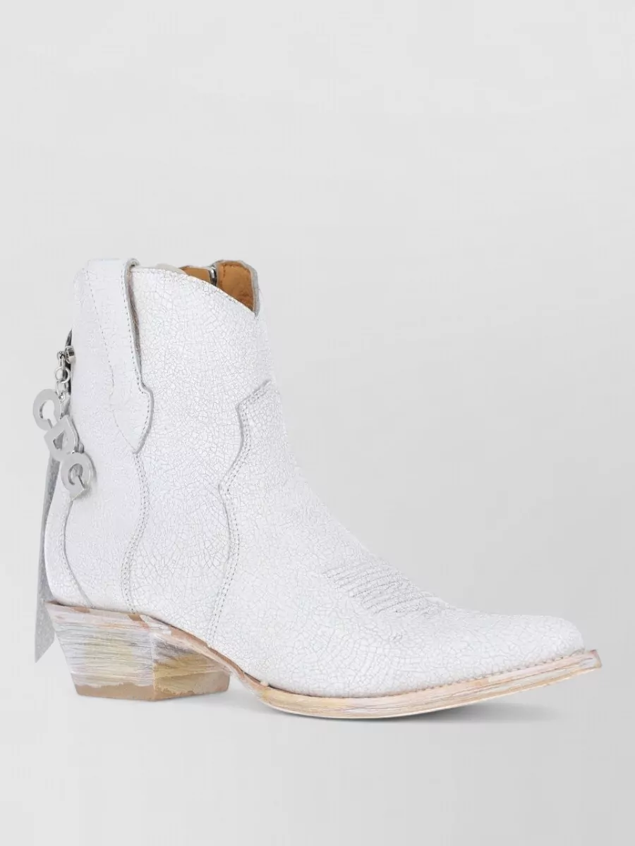 Comme des Garçons Leather ankle boots — The cracked white western boots keep everything in the same chalky palette and brand universe, adding a directional, grounded contrast to the airy volume of the dress and vest.