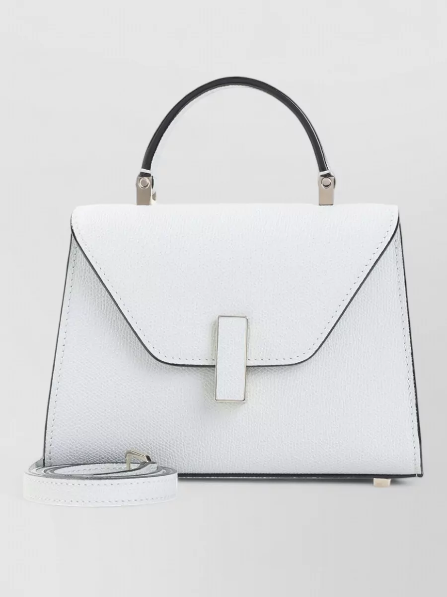 Valextra iside micro leather crossbody bag — The Valextra mini top-handle in crisp white mirrors the shirt’s optic clarity and sculptural sharpness, adding a small architectural accent that stays firmly in the quiet luxury realm.