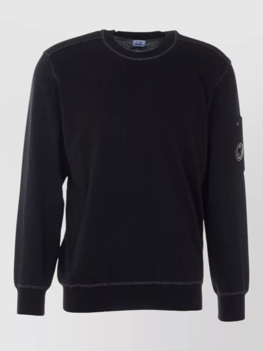 C.P. Company Cotton sweatshirt — The black crew sweatshirt with lens pocket lines up with the jacket’s minimalist utility, keeps the front clean under a zip shell, and avoids hood-on-hood bulk.