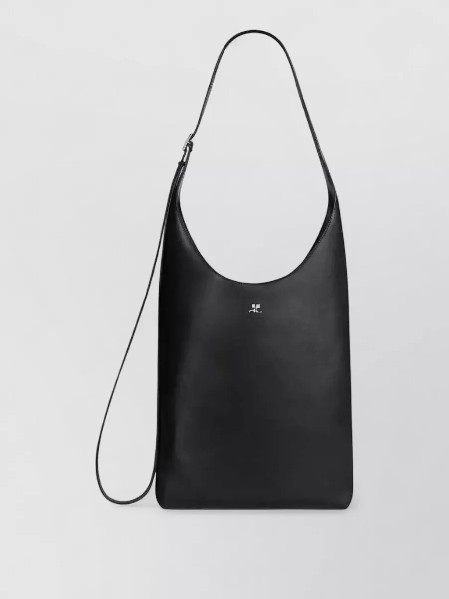 Courrèges Large leather shoulder bag — Bag G’s sleek black baguette shape and subtle logo echo the tank’s minimal branding and sit neatly under the arm, keeping the silhouette streamlined with the mini and wedge heel.
