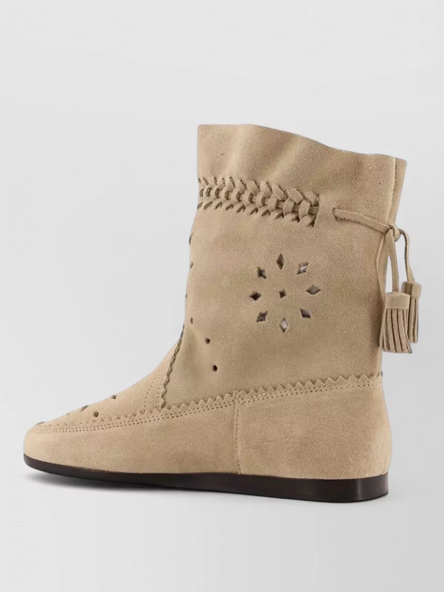 Isabel Marant Suede perforated tassel knee-high boots — The sand suede perforated ankle boots mirror the dress’s romantic boho spirit and SS feel, and the flat shape grounds the mini length in a relaxed but polished way.