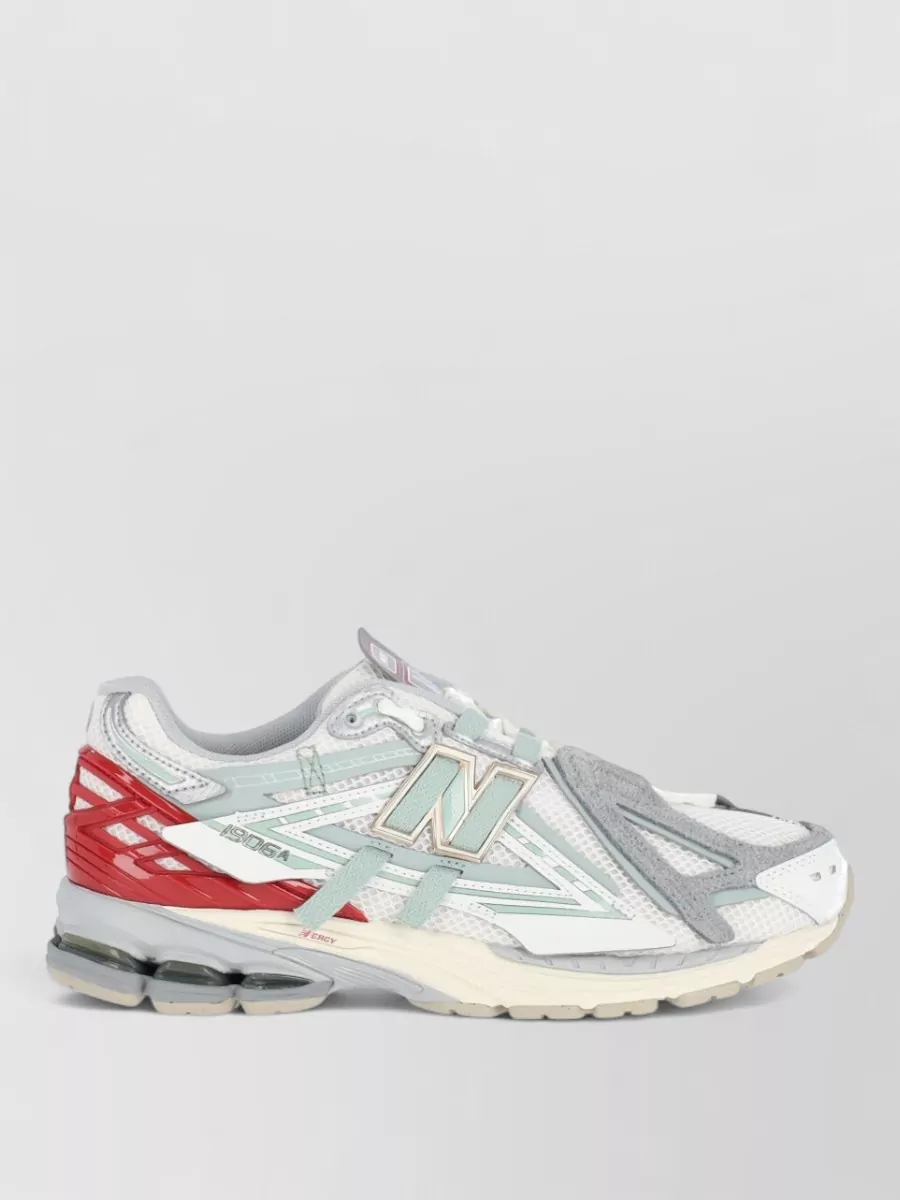 New Balance Low-top sneakers — The New Balance runner with a touch of brick red ties into the short-and-tee palette and keeps the whole outfit firmly in a modern sporty space with all-day comfort.